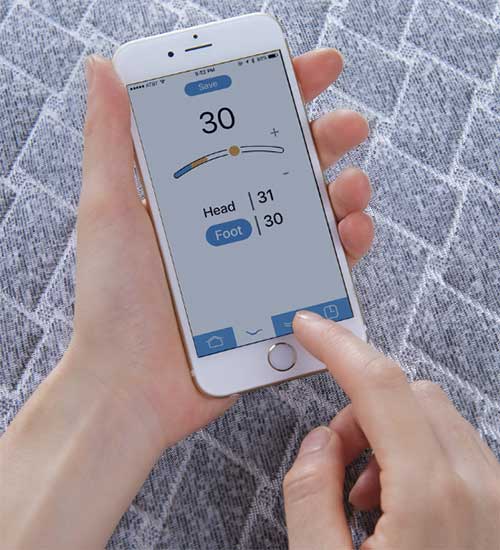 Hands holding cell phone using Nightstand App to adjust Head and foot angles.