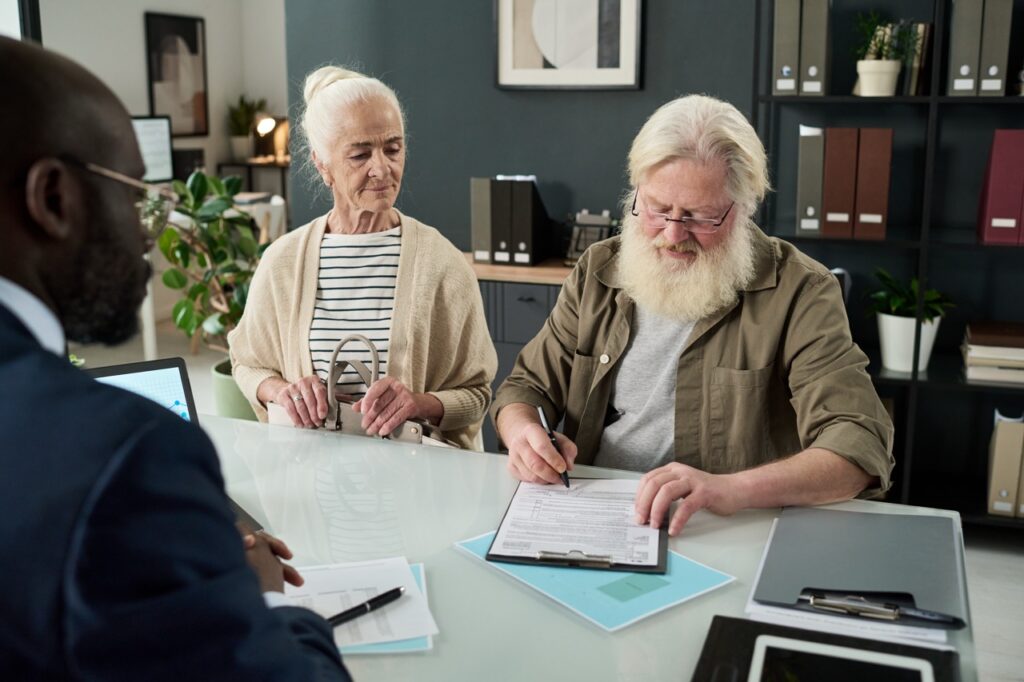 senior-man-signing-contract-in-office