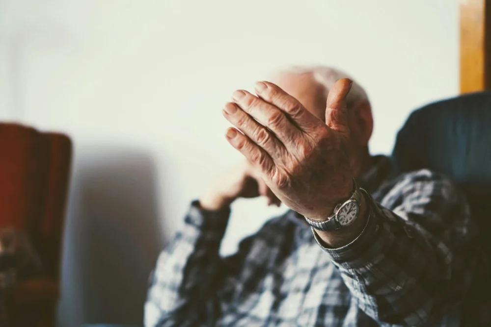 old man blocking his face with his hand: Photo by John Sekutowski on Unsplash