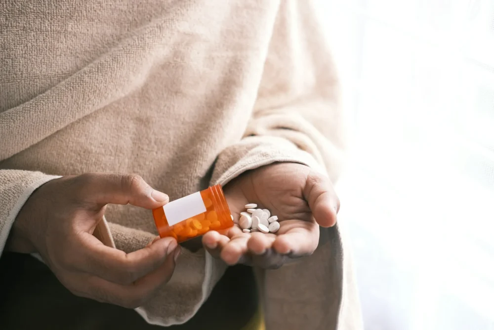 Person pouring white pills from an orange container: Photo by Towfiqu barbhuiya on Unsplash