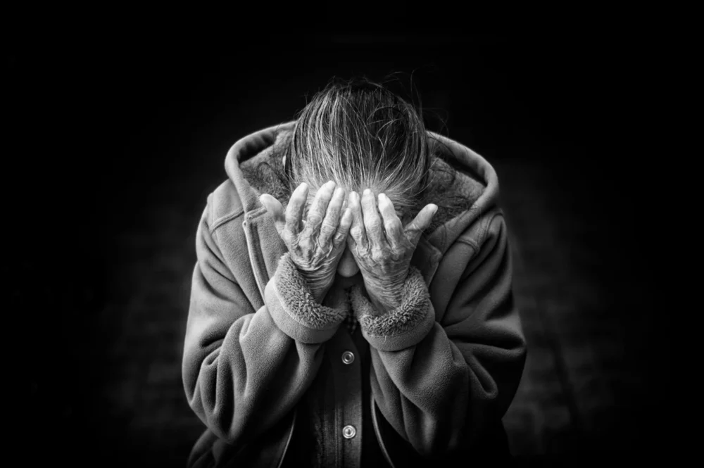 Old woman burying her face in her hands: Photo by Danie Franco on Unsplash