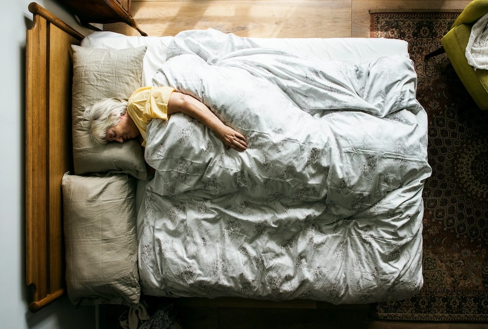 aerial view of a senior woman sleeping in her bed