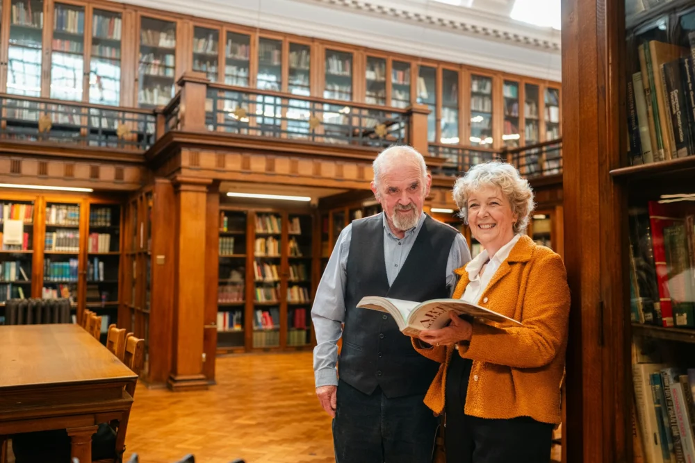 Elderly couple holding a book in a library: Photo by Centre for Ageing Better on Unsplash